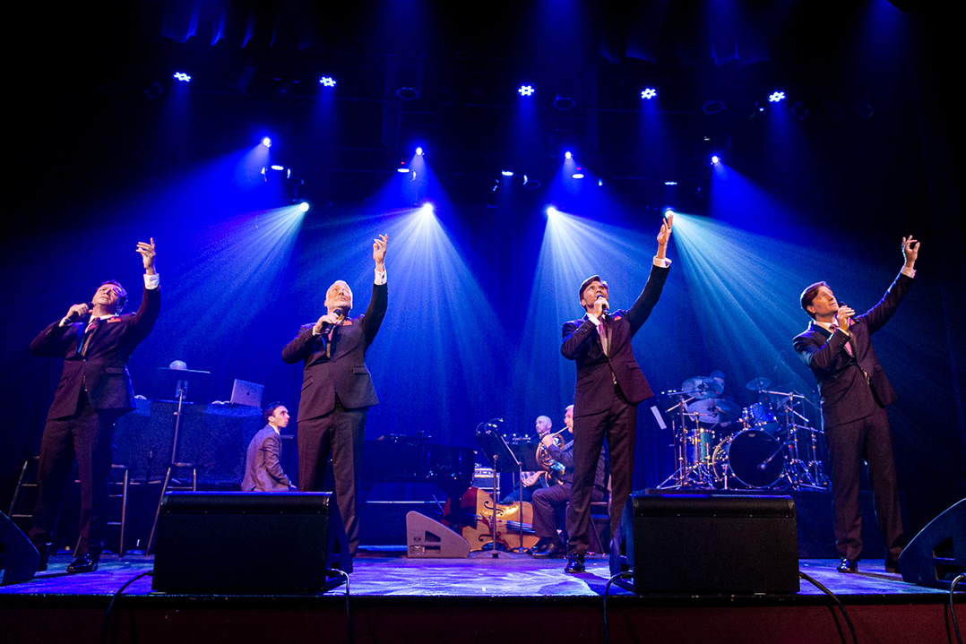 The Four Phantoms performing on stage under blue stage lights